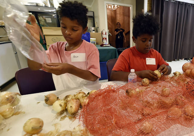 126077655_web1_TTL071819Food2
Brothers Ben and Orion Delgado of Wilkes-Barre bag produce for the market at the Keystone Mission in this 2019 file photo. Keystone Mission, which is currently helping 115 individuals facing homelessness, is looking for $5,000 for its Team Agape outreach program in an attempt to aid the local homeless population. The organization is one of many seeking community donations today, which is known as GivingTuesday.
Times Leader file photo