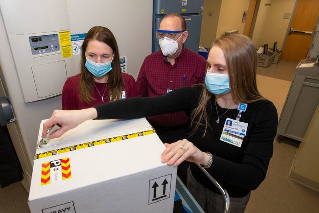 <p>Michelle Budzyn, assistant director of pharmacy services; Ronald Szklanny, inventory control specialist; and Kelly Bolesta, director of pharmacy services, open a delivery of the Pfizer COVID-19 vaccine at Geisinger Wyoming Valley Medical Center on Tuesday, December 15.</p>
<p>Courtesy of Geisinger</p>