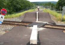 
			
				                                Then-Luzerne County Flood Protection Authority Executive Director Christopher Belleman closes a railroad crossing fence gate that was opened without permission atop the Wyoming Valley Levee in Edwardsville in 2024. The authority has received a state grant to design and construct an alternative public safety solution near the active rail line.
                                 Times Leader File Photo

			
		