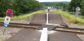 
			
				                                Then-Luzerne County Flood Protection Authority Executive Director Christopher Belleman closes a railroad crossing fence gate that was opened without permission atop the Wyoming Valley Levee in Edwardsville in 2024. The authority has received a state grant to design and construct an alternative public safety solution near the active rail line.
                                 Times Leader File Photo

			
		